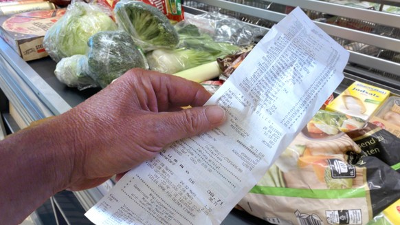 FOTOMONTAGE: Einkaufen immer teurer!Ein Blick auf den Kassenbon loest bei den Verbrauchern Entsetzen aus. Lebenshaltungskosten in Deutschland auf Rekordhoch. Waren,Gueter,Lebensmittel liegen auf einem ...