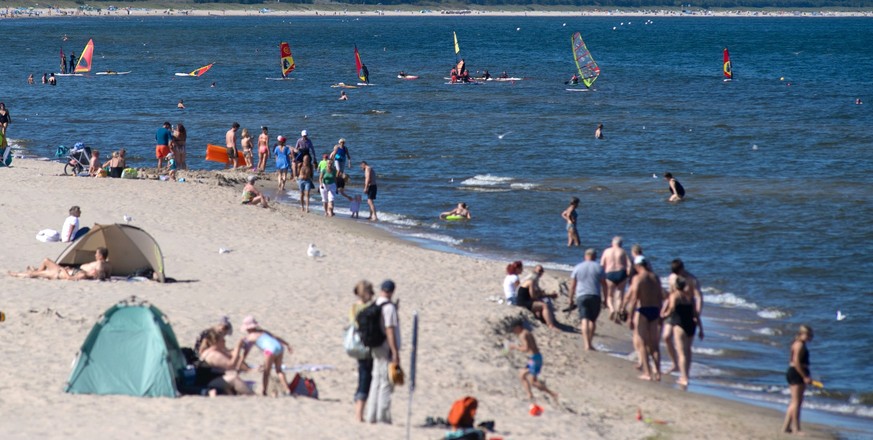 04.09.2023, Mecklenburg-Vorpommern, Zinnowitz: Touristen laufen bei sonnigem Wetter über der Strand oder gehen Baden. In den kommenden Tagen soll es laut Wetterdienst sonnig und warm werden. Foto: Ste ...