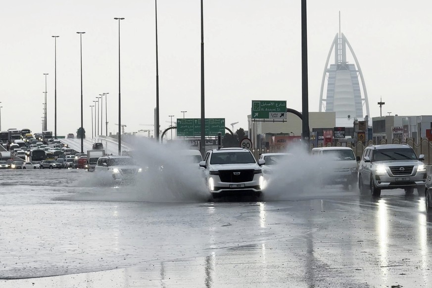 An SUV splashes through standing water on a road with the Burj Al Arab luxury hotel seen in the background in Dubai, United Arab Emirates, Tuesday, April 16, 2024. Heavy rains lashed the United Arab E ...