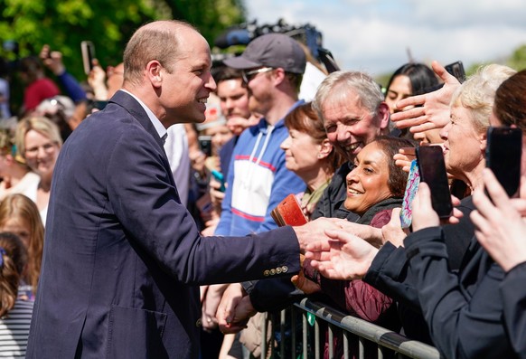 07.05.2023, Gro�britannien, Windsor: William (l), Prinz von Wales, unterh�lt sich mit Menschen w�hrend eines Rundgangs auf dem Long Walk in der N�he von Schloss Windsor, wo das Kr�nungskonzert zur Fei ...