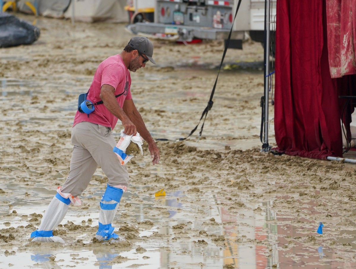 Syndication: Reno Gazette Journal A Burning Man participant makes their way through the mud. , EDITORIAL USE ONLY PUBLICATIONxINxGERxSUIxAUTxONLY Copyright: xTrevorxHughesx 21332728