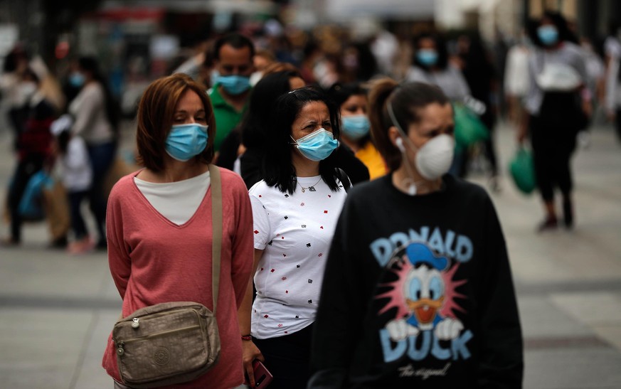 MADRID, SPAIN - JUNE 12: People line up in front of a shop observing the social distancing after the Spanish government relaxed the novel coronavirus (Covid-19) pandemic restrictions within the gradua ...