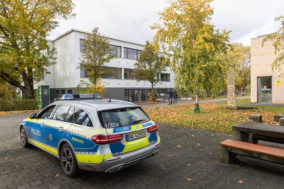 ARCHIV - 10.11.2023, Baden-Württemberg, Offenburg: Ein Einsatzfahrzeug der Polizei steht vor der Waldbachschule. Nach den tödlichen Schüssen wird die betroffene Schule am Montag wieder öffnen, allerdi ...
