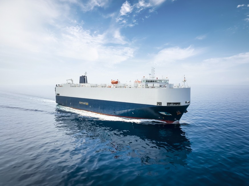 Front view of a big car carrier ship RO-RO (Roll on Roll off) traveling with speed over calm ocean