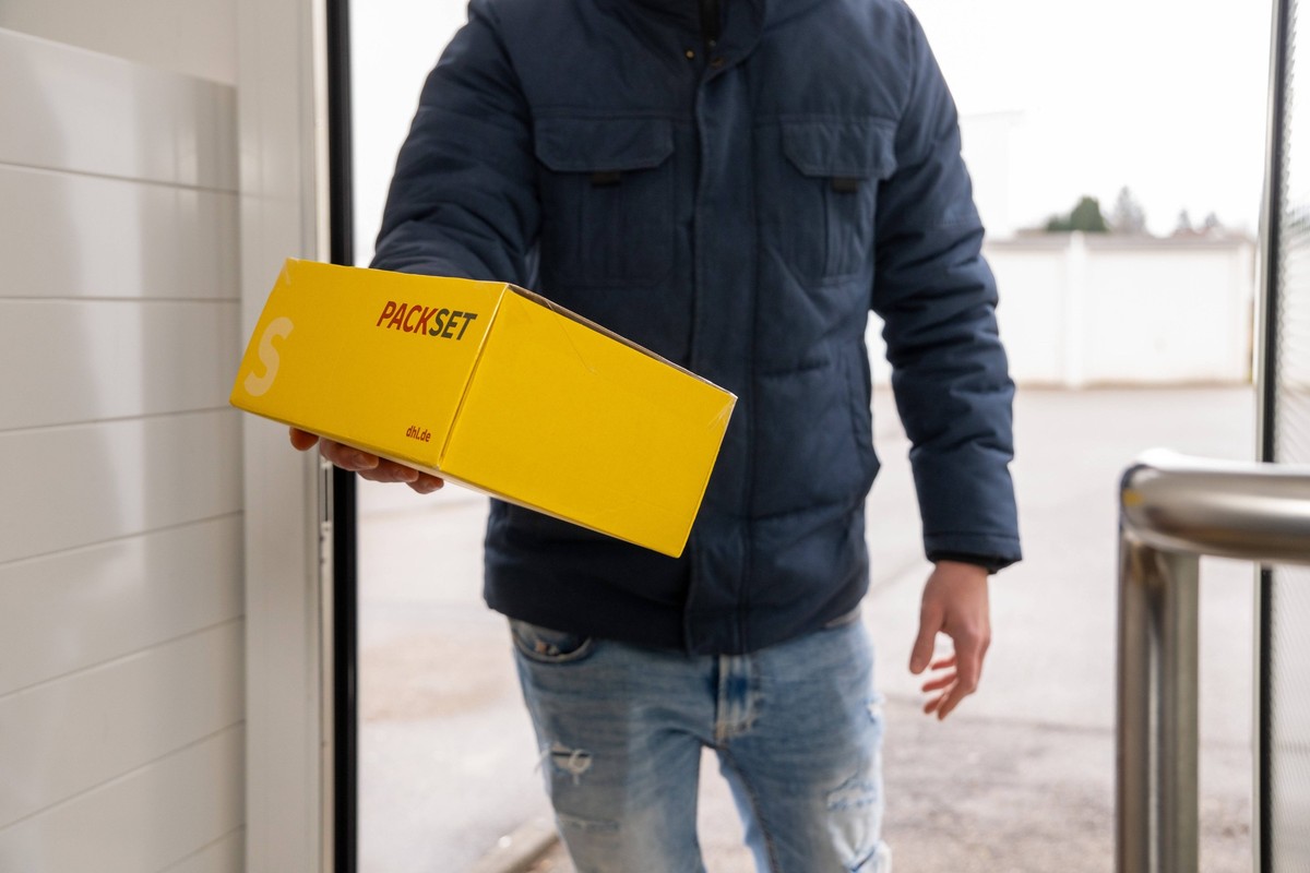 Bavaria, Germany - December 9, 2024: The letter carrier rings the doorbell and delivers a parcel directly to the front door. A familiar image in parcel shipping - personal delivery provides security a ...