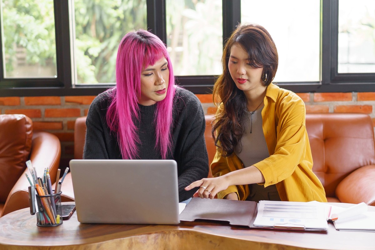 LGBTQ transgender man Beautiful Authentic Specialist with Pink Hair and Non-binary trans working together Working Design in creative workplace team work colleagues Gender equality LGBTQ transgender ma ...
