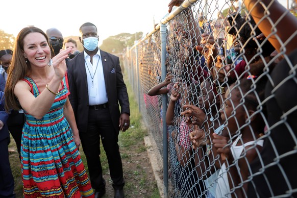 Royal visit to the Caribbean - Day 4. The Duchess of Cambridge waves at children during a visit Trench Town, the birthplace of reggae in Kingston, Jamaica, on day four of their tour of the Caribbean o ...