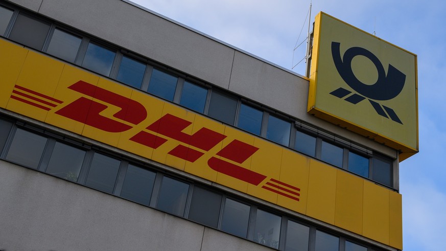 PRODUKTION - 21.11.2022, Sachsen-Anhalt, Magdeburg: &quot;DHL&quot; und das Logo der Deutschen Post ist an der Fassade des DHL Paketzentrums zu sehen. Die Post bereitet sich derzeit auf Weihnachten vo ...