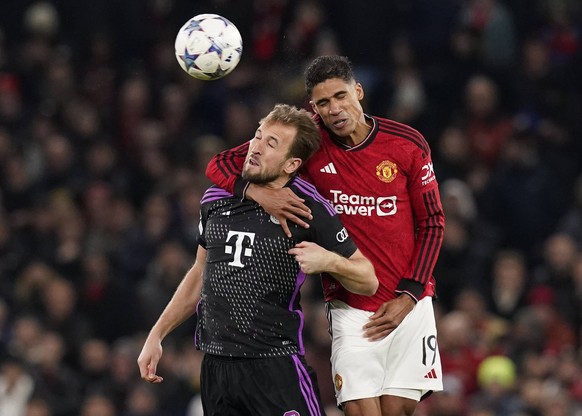 Manchester, England, 12th December 2023. Raphael Varane of Manchester United, ManU gets to grips with Harry Kane of Bayern Munich during the UEFA Champions League match at Old Trafford, Manchester. Pi ...