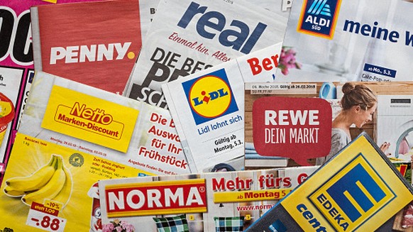 Amberg, Germany - February 26, 2018: Advertising leaflets of some German supermarket chains. Logos and brands are visible. Lidl, Aldi Süd, Penny Markt, Norma, Netto, Edeka, Real, Rewe.