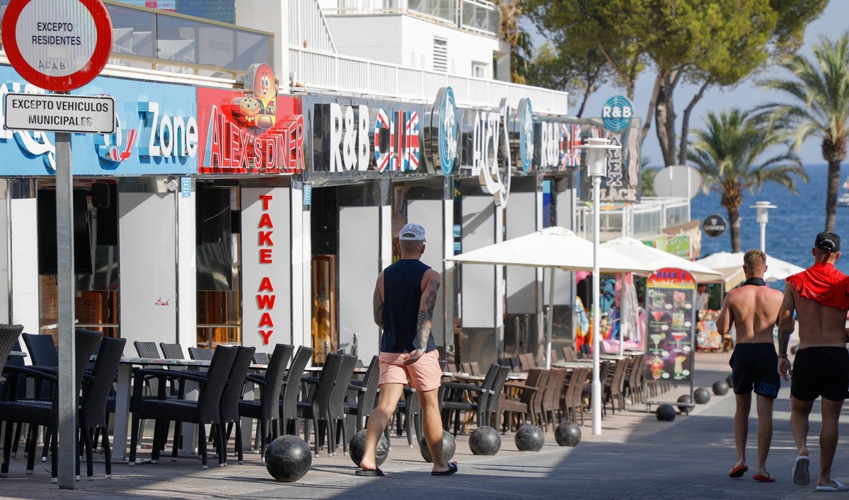 21.07.2022, Spanien, Calvia: Menschen spazieren durch die Party-Hochburg Magaluf. Wegen Verst��e gegen geltende Gesetze werden nun auf Mallorca acht Lokale vorsorglich zwangsgeschlossen. (zu dpa �Mall ...
