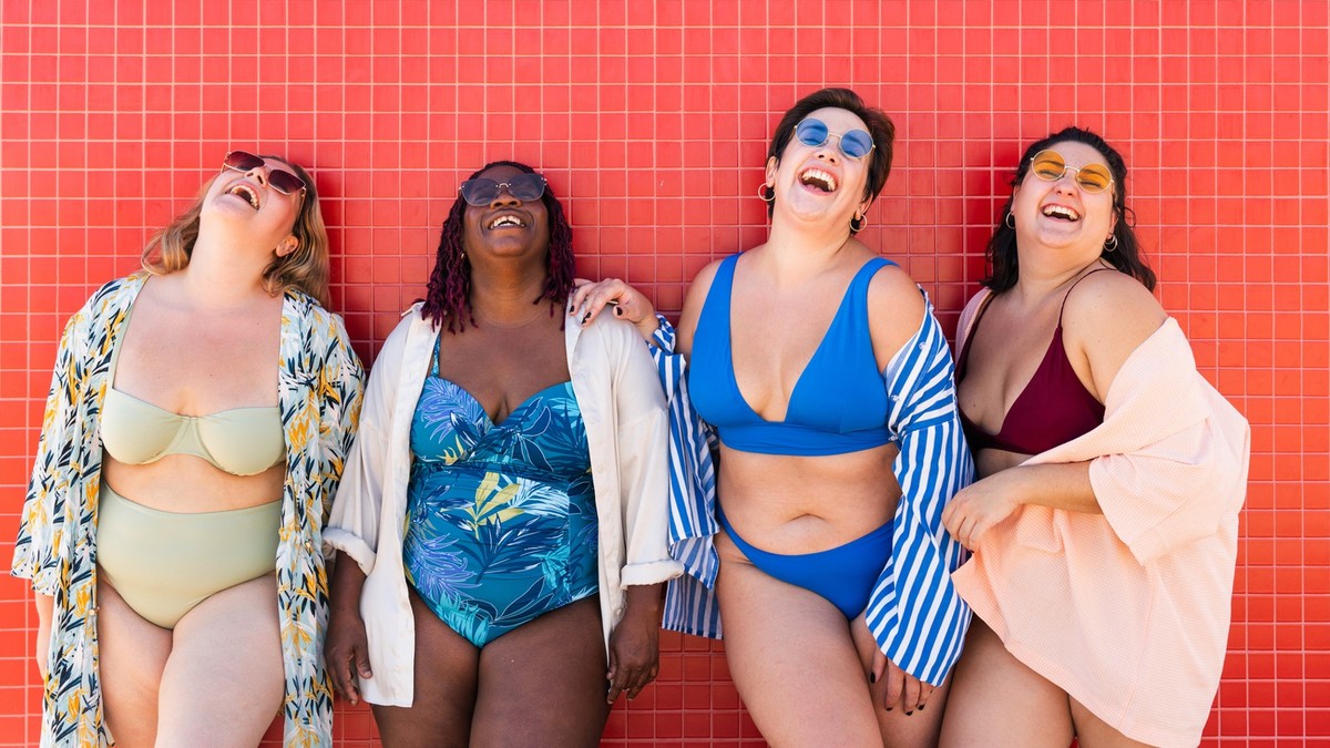 Group of beautiful plus size women with swimwear bonding and having fun at the beach - Group of curvy female friends enjoying summertime at the sea, concepts about body acceptance, body positive and s ...