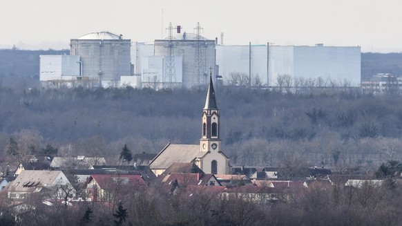 Der Kirchturm der katholischen Kirche St. Peter und Paul in Deutschland steht vor dem Atomkraftwerk Fessenheim in Frankreich.