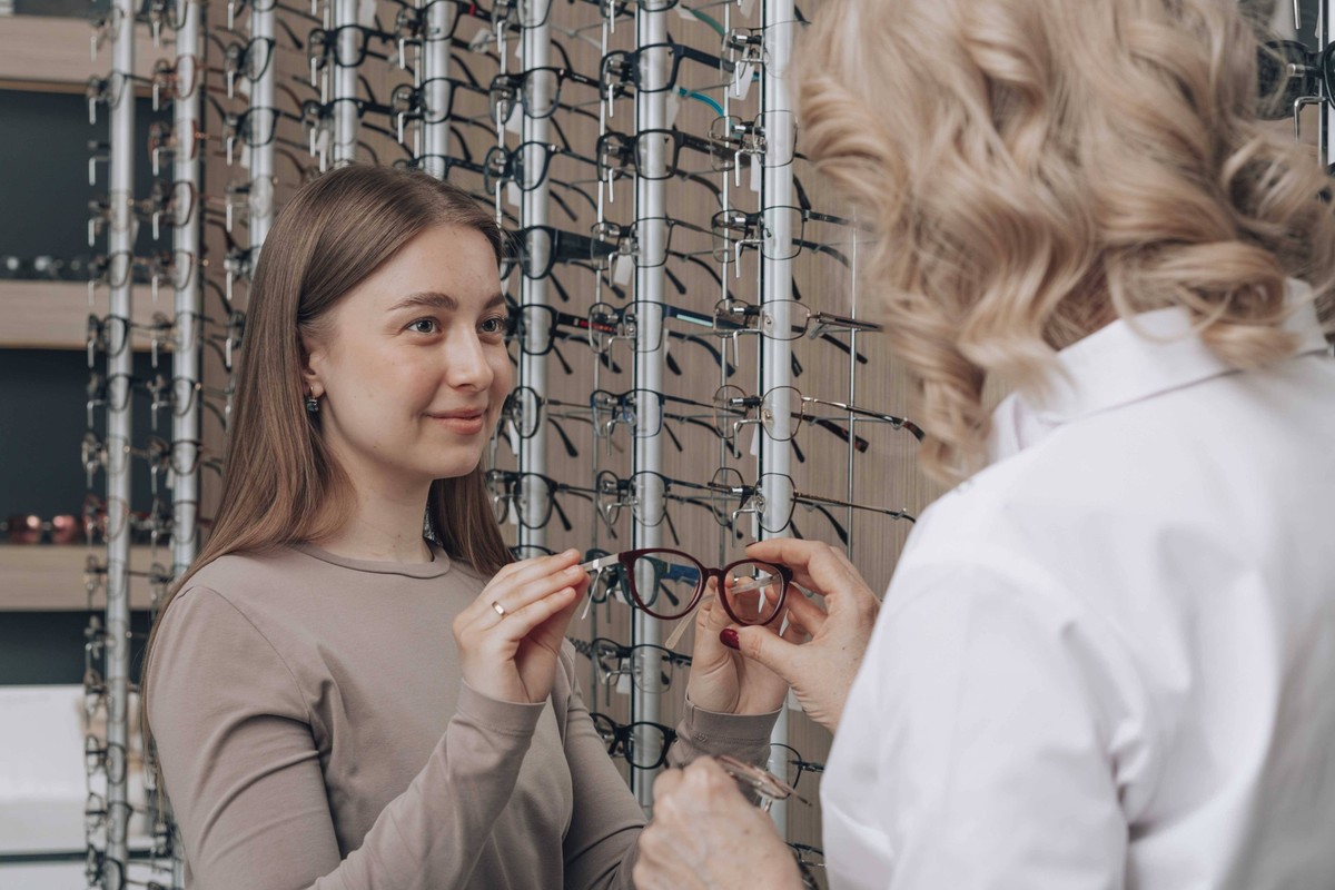 Doctor showing various eyeglasses at store model released, Symbolfoto property released, ADF00349