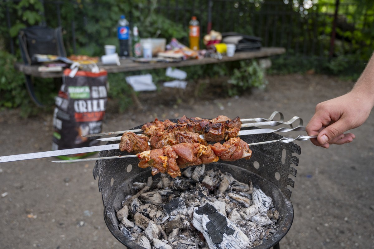 29.06.2022, Berlin: Ein Mann grillt im Volkspark Friedrichshain auf einem Grillplatz Fleischspie�e. Foto: Christophe Gateau/dpa +++ dpa-Bildfunk +++