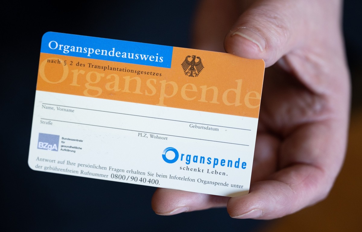 ARCHIV - 27.05.2022, Sachsen, Machern: Eine Frau h�lt einen Organspendeausweis in ihren H�nden. (zu dpa �Lauterbach f�r neuen Anlauf f�r Organspendereform - R�ckgang 2022�) Foto: Hendrik Schmidt/dpa + ...