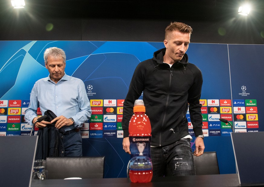 16.09.2019, Nordrhein-Westfalen, Dortmund: Trainer Lucien Favre (l) und Marco Reus kommen zu einer Pressekonferenz auf das Podium. Der BVB spielt am 17.09. in der Champions League gegen den FC Barcelo ...