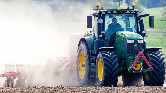 Ein Traktor fährt mit einer Drillmaschine über ein Feld und zieht eine große Staubwolke hinter sich her. Die seit Wochen anhaltende Trockenheit bringt die Bauern in Mecklenburg-Vorpommern in eine schw ...