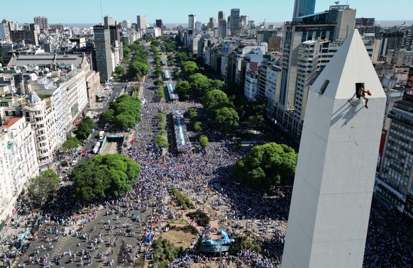 20.12.2022, Argentinien, Buenos Aires: Fußball, WM: Nach der Ankunft von Weltmeister Argentinien in der Heimat: Argentinische Fußballfans versammeln sich vor dem Obelisken-Denkmal und warten auf die a ...