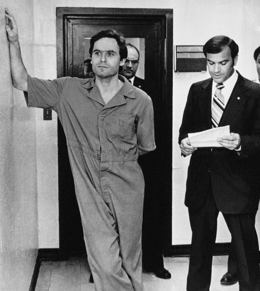 Theodore Bundy makes himself comfortable as Sheriff Ken Katsaris reads the indictment handed down by the Leon County Grand Jury, July 27, 1978 in Tallahassee, Fla. Bundy was indicted on two counts of  ...