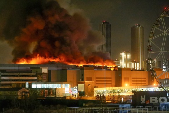 ARCHIV - 22.03.2024, Russland, Moskau: Ein massiver Brand ist am Freitag, 22.03.2024 über dem Crocus City Hall am westlichen Rand von Moskau zu sehen. Der Terroranschlag bei Moskau ist nach den Worten ...