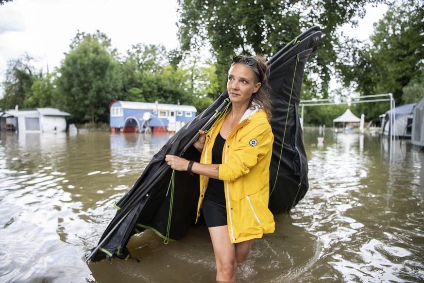 Madhu und Joe helfen bei der Rettung von Hab und Gut in ihrem Wohnwagen auf dem ueberfluteten Campingplatz Reussbruecke, aufgenommen am Mittwoch, 14. Juli 2021 in Ottenbach. (KEYSTONE/Ennio Leanza).