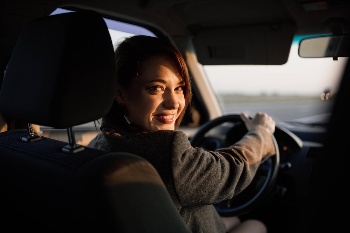 Junge, h�bsche, l�chelnde Taxifahrerin in Jacke begr��t die Fahrg�ste freundlich, freundlicher Service *** Boy, pretty, smiling Taxi driver in Jacket welcomes the Passengers friendly, Friendly Service ...