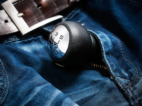 Gear shift lever in the zipper of man's jeans.