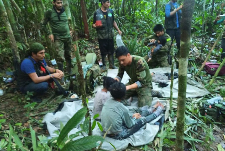 dpatopbilder - HANDOUT - 09.06.2023, Solano-Dschungel: Auf diesem von der Pressestelle der kolumbianischen Streitkräfte veröffentlichten Foto kümmern sich Soldaten und indigene Männer um die vier Gesc ...