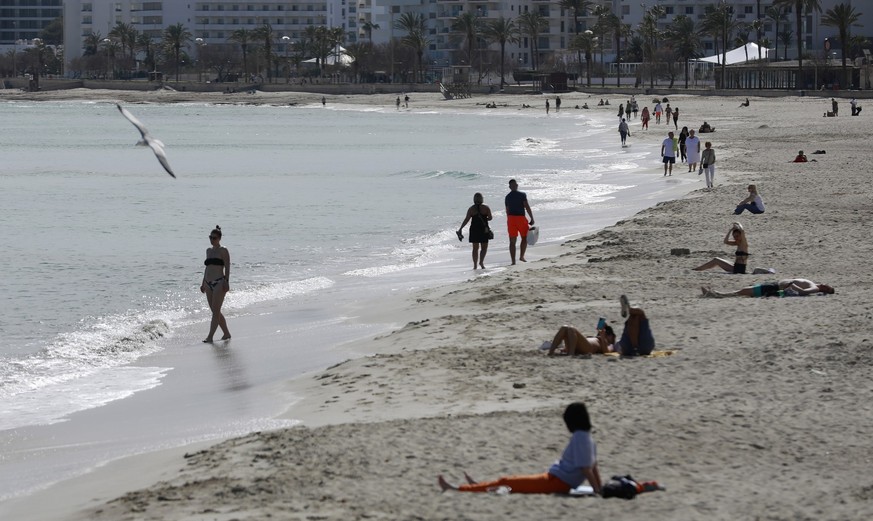 10.03.2023, Spanien, Son Servera: Menschen sonnen sich am Strand von Cala Millor auf Mallorca. Ungewöhnlich hohe Temperaturen für diese Jahreszeit werden für dieses Wochenende auf Mallorca erwartet. F ...