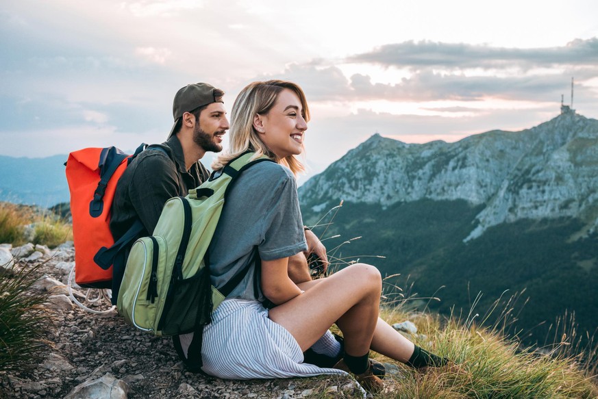 young couple of hikers enjoying the beautiful nature from high above