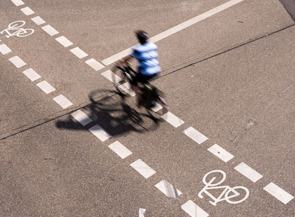 ARCHIV - 23.08.2022, Baden-Württemberg, Freiburg: Ein Radfahrer fährt in der Innenstadt von Freiburg auf einem Fahrradschutzstreifen. Wenn die Temperaturen im Sommer auf neue Höhen steigen, wird es vo ...