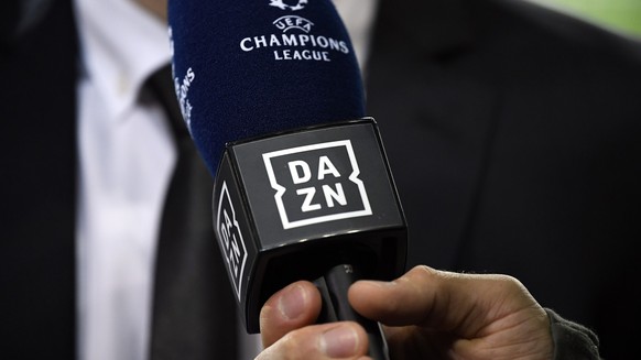 ARCHIV - 28.11.2018, Portugal, Porto: Ein Reporter hält ein Mikrofon des Streamingdienstes DAZN während eines Interviews fest. Der Internet-Anbieter DAZN hat sich das größte Rechtepaket an der Fußball ...