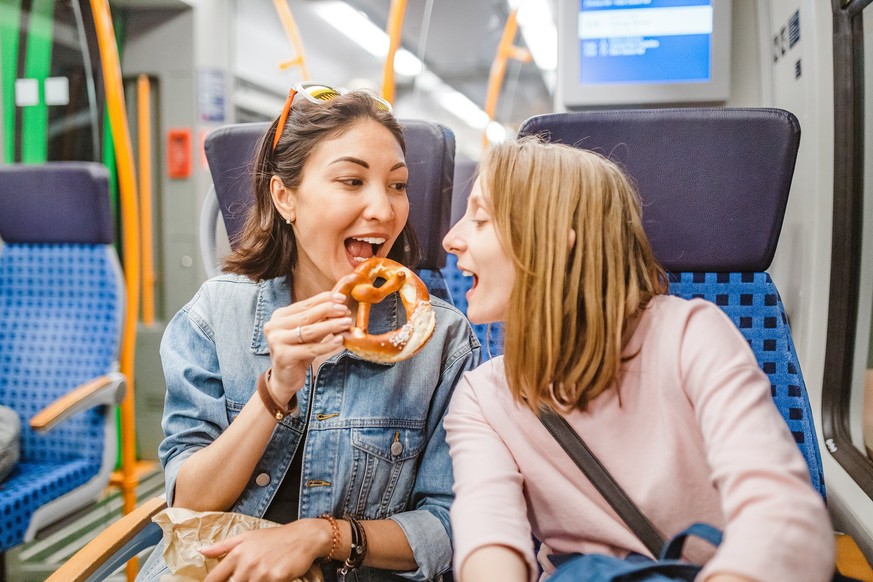 woman eating pretzel while traveling by train