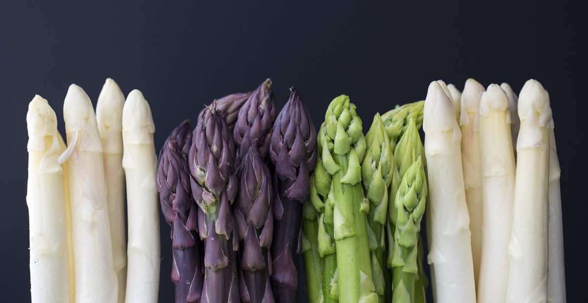 white, green and purple asparagus on dark background