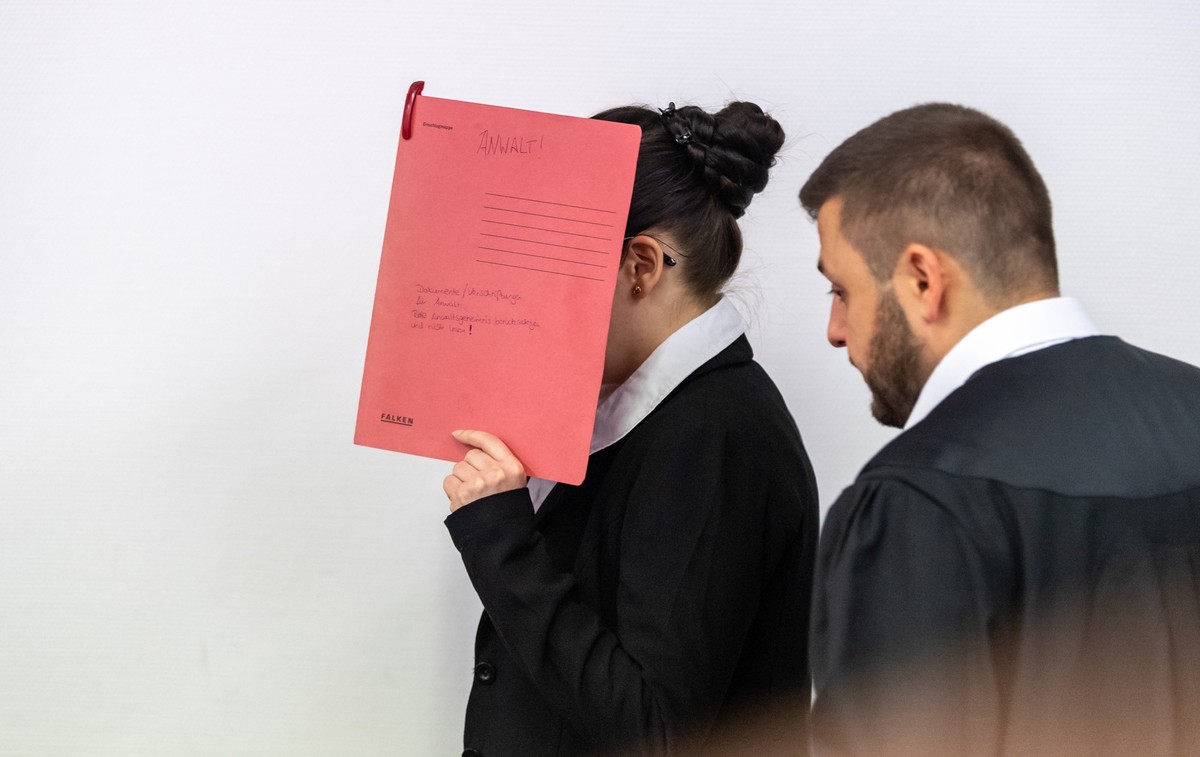 ARCHIV - 04.07.2019, Bayern, München: Die Angeklagte Jennifer W., die sich der Terrormiliz Islamischer Staat (IS) im Irak angeschlossen haben soll, hält sich beim Betreten des Gerichtssaals einen rote ...