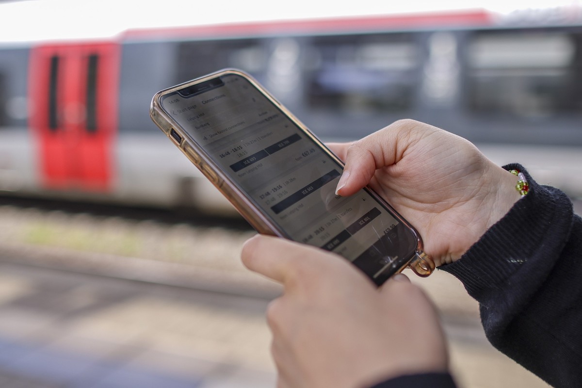 ILLUSTRATION - 14.05.2025, Sachsen, Leipzig: Eine Frau steht mit ihrem Mobiltelefon und der App DB-Navigator auf einem Bahnsteig. Am 19. Mai 2025 wird das Landgericht Frankfurt über die Rechtmäßigkeit ...