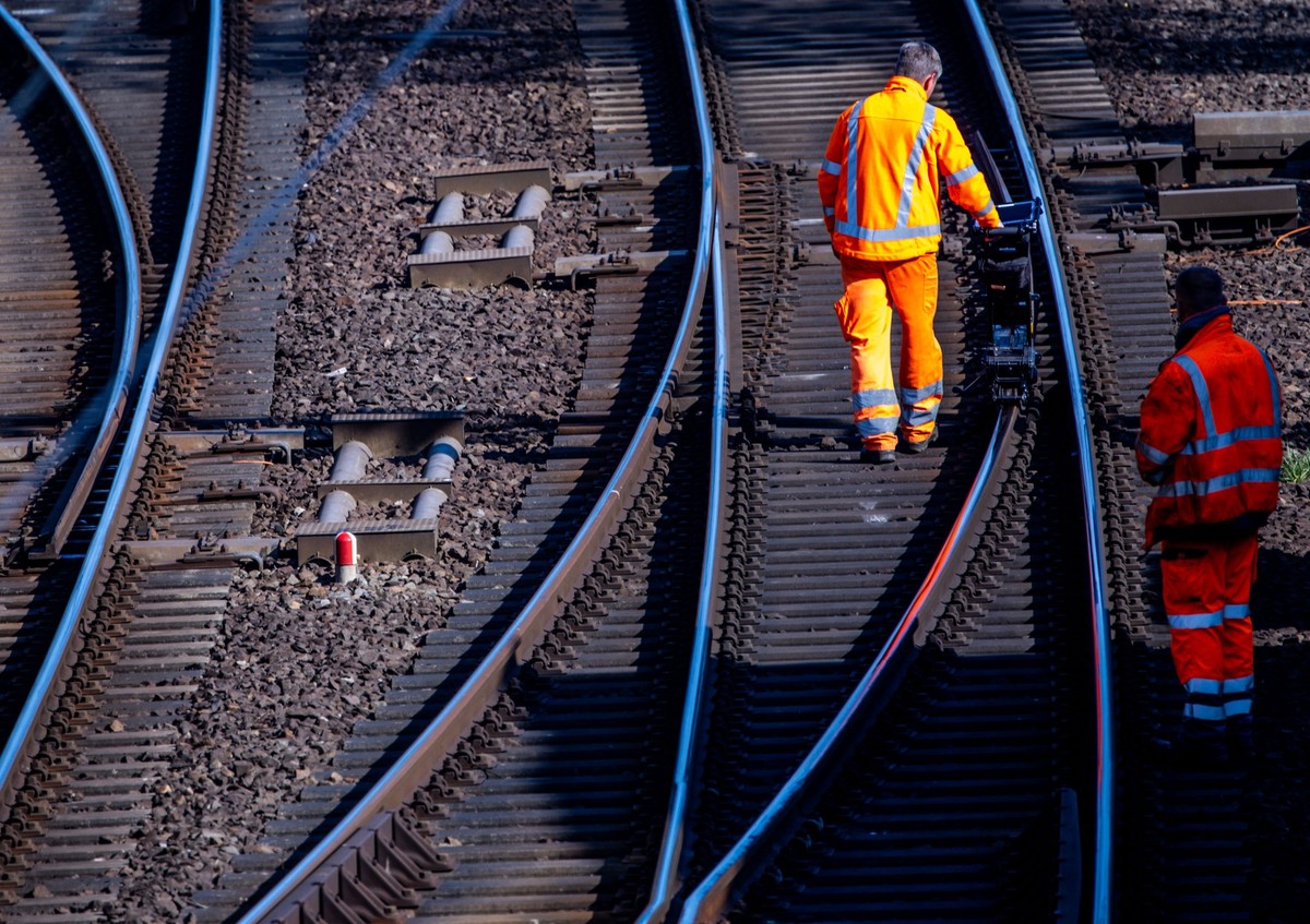ARCHIV - 09.04.2025, Mecklenburg-Vorpommern, Schwerin: Bauarbeiter vermessen eine Schiene auf der Bahnstrecke Ludwigslust - Wismar kurz vor dem Hauptbahnhof. Die Deutsche Bahn (DB) will 2025 mehr als ...
