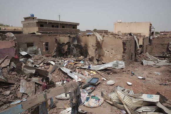 25.04.2023, Sudan, Khartum: Ein Mann geht an einem Haus vorbei, das bei den jüngsten Kämpfen getroffen wurde. Im Sudan sind vor mehr als einer Woche schwere Kämpfe zwischen dem Militär und Paramilitär ...