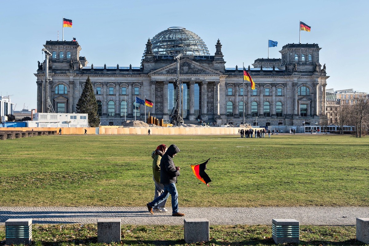 08.01.2024,Berlin,Reichstagsgebäude Reichstag Sitz des Deutschen Bundestages.Eine Person trägt eine Deutschlandflagge *** 08 01 2024,Berlin,Reichstag building Reichstag seat of the German Bundestag A  ...