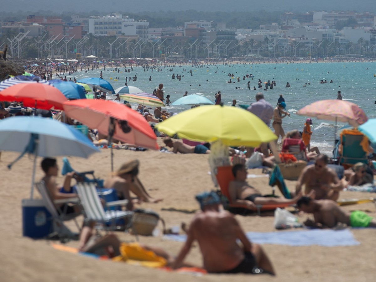 07.06.2025, Spanien, Palma: Menschen schwimmen und sonnen sich am Strand von Arenal auf Mallorca. Foto: Clara Margais/dpa +++ dpa-Bildfunk +++