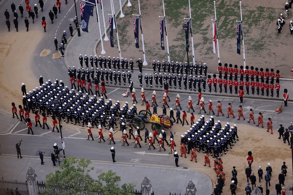 The State Gun Carriage carries the coffin of Queen Elizabeth II, draped in the Royal Standard with the Imperial State Crown and the Sovereign s orb and sceptre, in the Ceremonial Procession following  ...