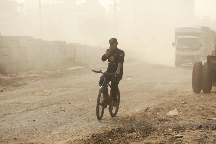 January 4, 2022, Dhaka, Bangladesh: People cover their noses and mouths to protect themselves from dust on a street at Matuail, in Dhaka, Bangladesh, January 4, 2022. Dust pollution reaches an alarmin ...