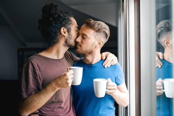 Couple of gay men drinking coffee at home, morning ritual of same sex lovers, gay pride and marriage lifestyle