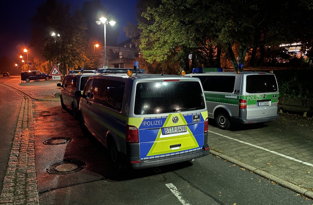 20.10.2023, Bayern, Hollfeld: Polizeifahrzeuge stehen vor der Gesamtschule in Hollfeld (Landkreis Bayreuth), die nach einer Bombendrohung geschlossen ist. Die Polizei sei im Einsatz und durchsuche das ...