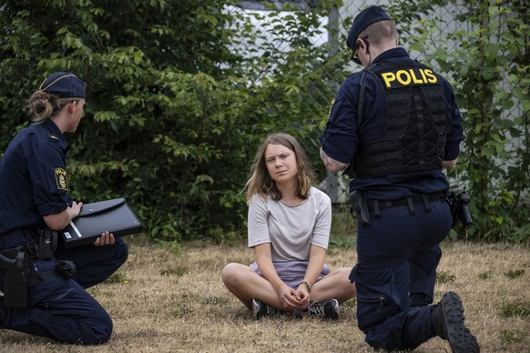 ARCHIV - 19.06.2023, Schweden, Malmö: Zwei Polizeibeamte sprechen mit Greta Thunberg, Klimaaktivistin aus Schweden, während sie Aktivisten der Organisation «Ta Tillbaka Framtiden» (Nimm die Zukunft zu ...