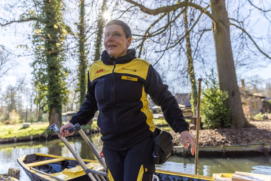 12.04.2023, Brandenburg, Lübbenau/Ot Lehde: Andrea Bunar lädt Pakete auf ihren Kahn. Die Postzustellerin, für die es bereits die zwölfte Saison auf dem Wasser ist, liefert ab sofort im Spreewald-Dorf  ...