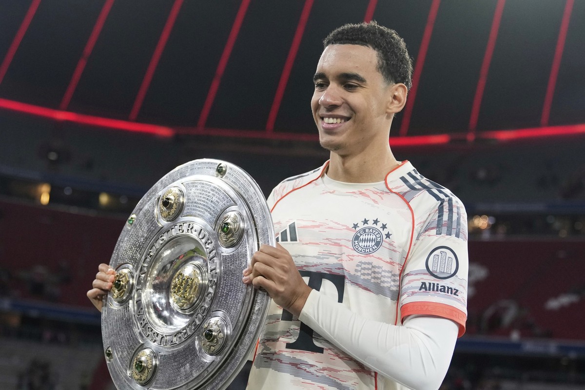 Bayern&#039;s Jamal Musiala poses with the championship shield after the German Bundesliga soccer match between FC Bayern Munich and Borussia Moenchengladbach in Munich, Germany, Saturday, May 10, 202 ...