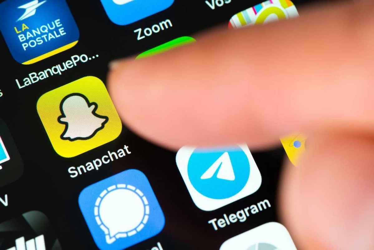 Finger pointing at Snapchat app icon on Apple iPhone screen, BAYONNE, FRANCE - CIRCA JANUARY 2021: Finger pointing at Snapchat app icon on Apple iPhone screen. Snapchat is a multimedia messaging app d ...