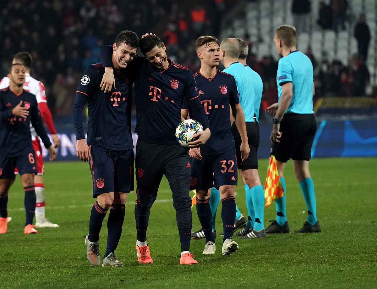 Robert Lewandowski mit dem Spielball im Arm herzt seinen Mitspieler Benjamin Pavard.